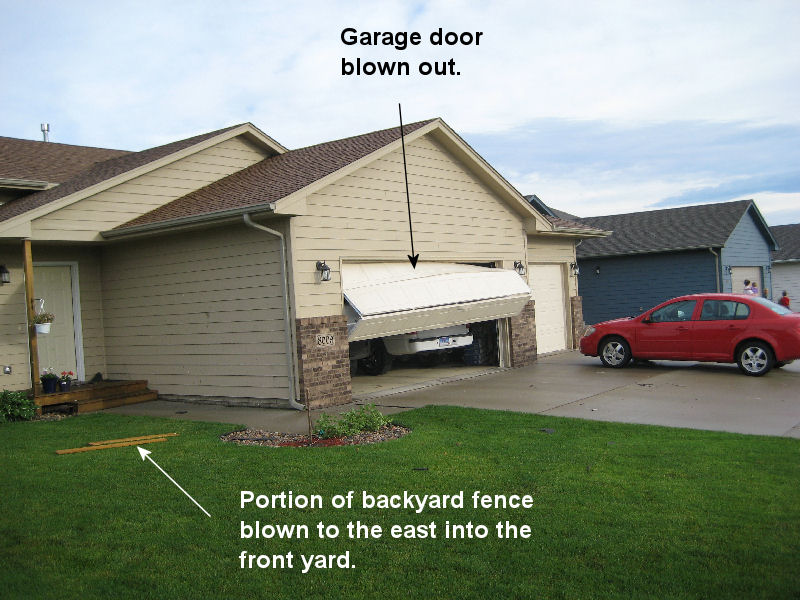 Garage door blown out by wind.